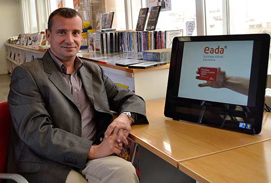 El profesor de EADA David Roman junto a una de las imágenes de la campaña “Pastillas contra el dolor ajeno” impulsada por MSF a finales de 2011.